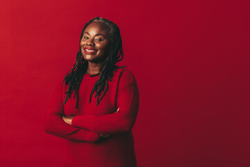 Happy woman with dreadlocks smiling at the camera in a studio