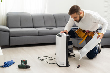 young man changing - fixing a dirty air purifier HEPA filter after using for a long time. A repairman replacing and installing the air purifier filter. Healthcare and wellbeing