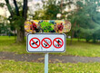 No smoking, no dogs, and no littering sign at the skate park with a used skateboard on it
