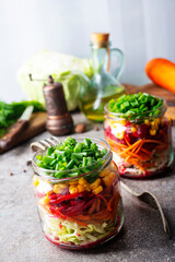 Wall Mural - Fresh salad of autumn vegetables - purple and green cabbage, carrots, green onions. salad in bank