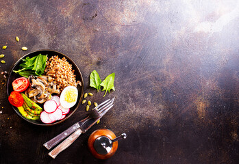 Poster - Cooked Buckwheat with avocado and mushrooms served in a bawl for breakfast. Gluten free meal.