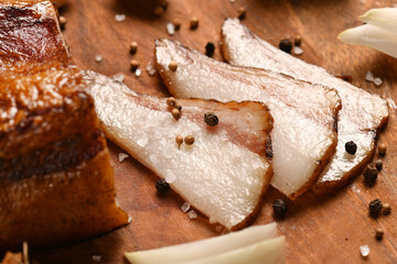 still life of food in a rural style on a dark wood background, sliced lard and garlic, salt and pepper, concept of fresh vegetables and healthy food