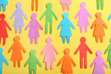 Wall Mural - Many different paper human figures on yellow background, flat lay. Diversity and inclusion concept