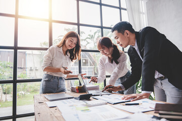 Wall Mural - Young colleagues discussing business and price chart analyzes business people on the table great in modern coworking office teamwork concept. Calculate personal tax for customers