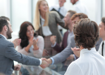 Fototapete - business partners shaking hands as a sign of cooperation