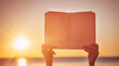 © candy1812 - Human hands holding empty textbook outdoors on the sunset