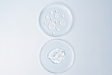 Wall Mural - Transparent drops of cosmetic product serum gel in petri dish. Liquid texture with bubbles on blue background. Skincare products, natural cosmetic. Beauty concept for face and body care