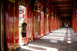 Turista con sombrero vietnamita descubriendo los pasillos y corredores de la antigua ciudad imperial de Hue