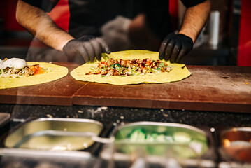 process of preparing traditional Turkish fast food - grilled meat or shawarma or kebab. chef hand cooking food