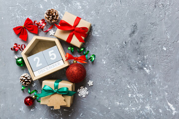 Christmas calendar 25 december. Christmas gift, fir branches, pine cones. Flat lay, top view. New Year decorations on a colored background