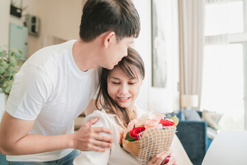 Wall Mural - handsome husband giving flowers to beautiful wife. cute surprised girlfriend got present from happy boyfriend. adult couple with good comfortable relationship give lovely flowers for romantic touch