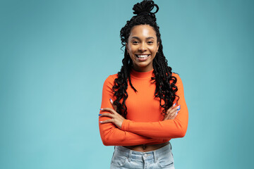 Young lovable woman with african hairstyle laughing during indoor photoshoot. Graceful cute girl