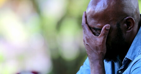 Wall Mural - Worried African man covering face with hand having difficulties