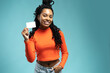 © opolja - Young beautiful woman showing copy space on empty blank sign or gift card isolated on blue background