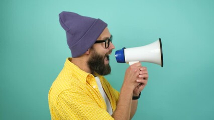 Wall Mural - Funny emotional guy with megaphone, talking proclaiming news, loudly announcing advertisement, hot news announce discounts sale hurry up communication concept. Studio video isolated on blue background