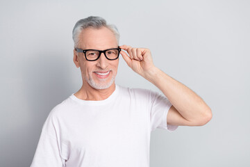 Portrait of cheerful person hand touch eyeglasses look camera toothy smile isolated on grey color background