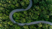 Aerial Top View Asphalt Road In Forest With Car Motion Blur, Winding Road Through The Forest, Car Drive On The Road Between Green Forest.