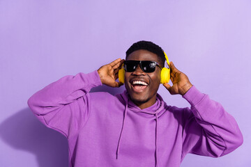 Wall Mural - Photo of cheerful positive person hands touch headphones good mood isolated on purple color background