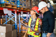 © winnievinzence - Male foreman looking at checklist report and discussing with female worker at the warehouse factory. Logistics worker checking at stock distribution before shipping delivery.