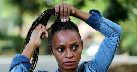 Wall Mural - African woman adjusting dread hair outside