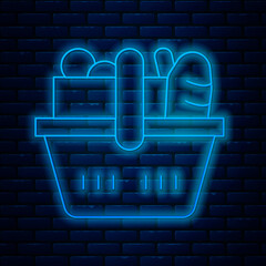 Poster - Glowing neon line Shopping basket and food icon isolated on brick wall background. Food store, supermarket. Vector