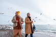 © Milles Studio/Stocksy - Optimistic mom and daughter on beach near seagulls