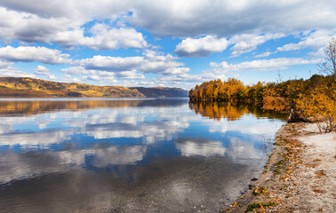 Wall Mural - picturesque autumn landscape of baikal lake with reflection of clouds in blue calm water near shaman