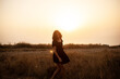 © Вероника Зеленина - Beautiful sexy woman with natural curly hairs posing in the nature against  the field with dry grass and sky