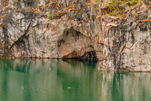 Picturesque Vegetation On A Sheer Rock Wall And A Lake At The Foot Of The Cliff