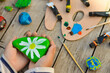 © Ирина Старикова - Outdoor workshop in summer. A selective focus of a schoolboy boy holding a painted flat stone in his hands. Do it yourself.