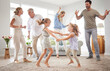 © David L/peopleimages.com - Happy, dance and love with big family in living room together for crazy, energy and excited. Lifestyle, freedom and celebration dancing at modern home with parents, children and grandparents