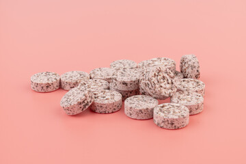 Wall Mural - Heap of medicine colored pills, tablets on a pink background