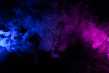 Clouds Of Colorful Swirling Blue And Pink Smoke Dark Abstract Background