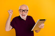 © deagreez - Photo of mature man rejoice victory lucky use tablet hooray triumph isolated over yellow color background