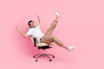 Wall Mural - Full size photo of playful guy manager fooling ride fast cozy office chair isolated on pastel color background