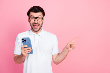 Poster - Photo of cheerful funky man arm direct present empty space cool proposition buy new device telephone isolated on pink color background