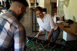 © JustLife - Colleagues having fun at work. Businessman and businesswoman playing table soccer.