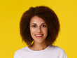 © Svetlana - Portrait of african american woman with clean healthy skin and afro hair looking at camera smiling wearing white t-shirt isolated on yellow background. Young cheerful dark skin girl with curly hair