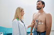 Man using Holter with ECG sensors to monitor his heart health under supervision of licensed cardiologist