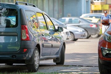 Wall Mural - Cars parked in line on city street side. Urban traffic concept