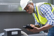 © amorn - Male plumber engineer working in sewer pipes area at construction site. African American male plumber worker maintenance sewer pipes network system at construction site