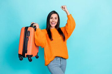 Sticker - Portrait of delighted astonished person hold suitcase raise fist celebrate isolated on teal color background