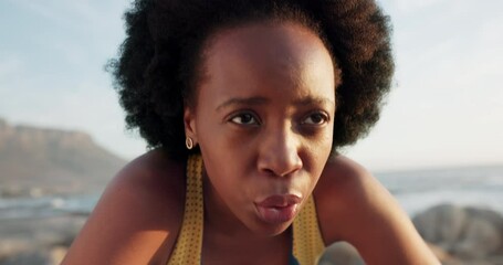 Wall Mural - Tired, portrait and black woman doing exercise at the beach, breathing after running by the sea and fitness training by the ocean. Face of athlete runner with motivation for sports marathon in nature