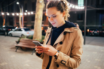 Wall Mural - Young woman standing on city street at night