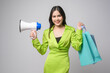 © tonefotografia - Beautiful woman holding megaphone and shopping bag over white background studio, shopping and finance concept.