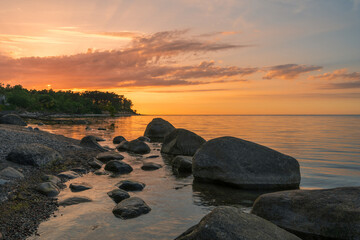 Wall Mural - Wonderful orange sunset on the rocky coast of the sea