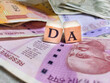 © tanmoythebong - Concept of DA or Dearness allowance with wooden bids or blocks on indian rupees notes.