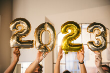 Group Of Friends At A Party Celebrate Happy New 2023 Year With Elegant Inflatable Gold Text - People Have Fun Together At Home