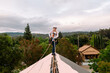 © ByLorena/Stocksy - Woman working on roof with security harness