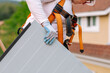 © ByLorena/Stocksy - Crop female roofer holding solar pannel